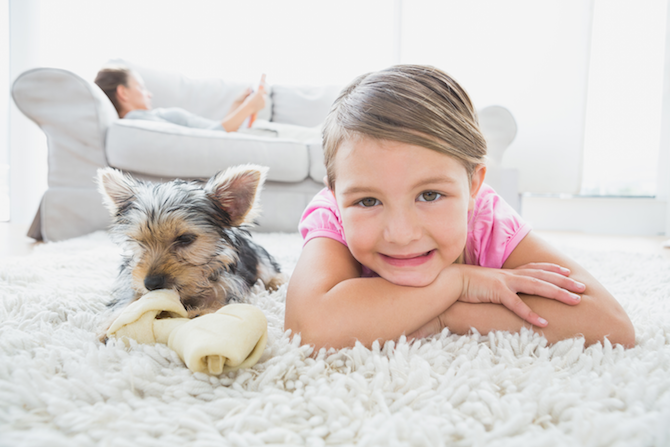 kid smiling on floor with dog